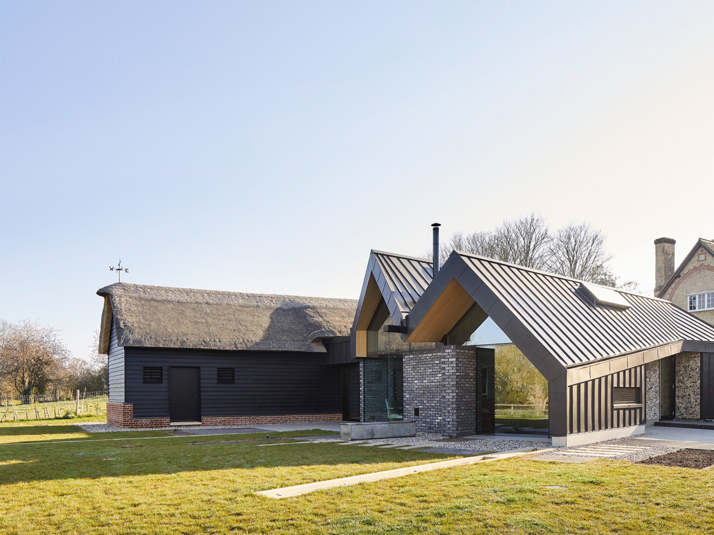 pitched zinc roofs meeting thatched roof at eye-level | cambridge architects CDC Studio