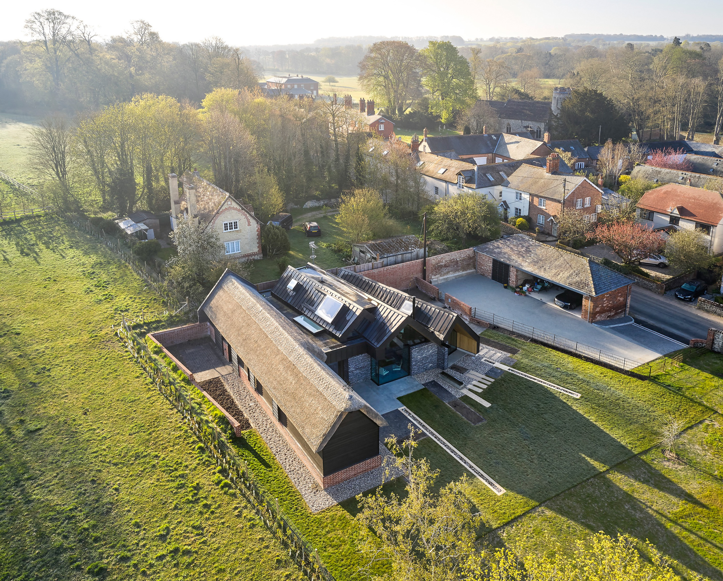 Aerial view of sunrise over thatch and zinc cambridgeshire roof | cdc studio cambridge architects