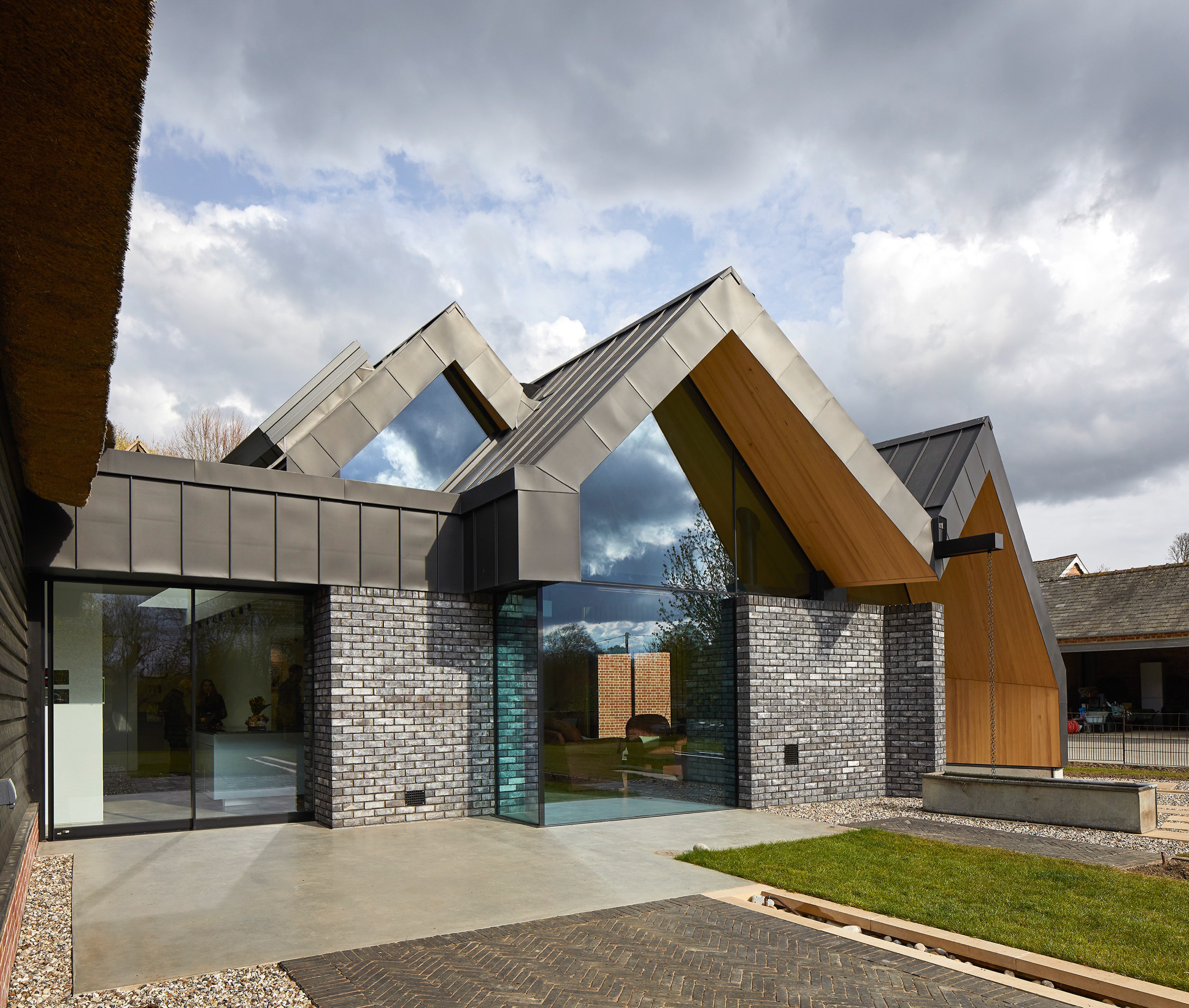 Multiple large zinc pitched roofs with glass front | cdc studio cambridge architects