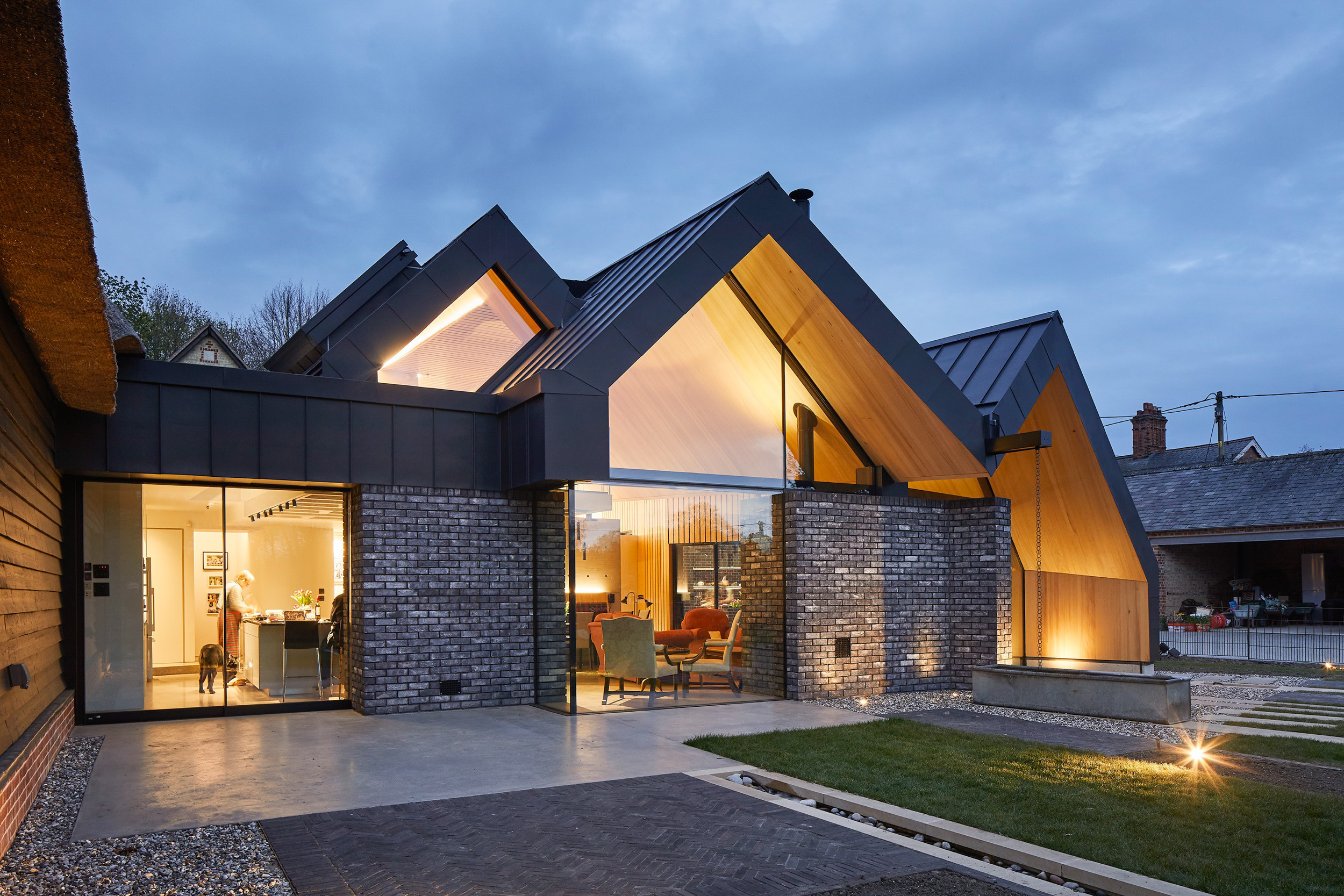 Pitched zinc roofs of Cambridgeshire house at night | cdc studio cambridge architects