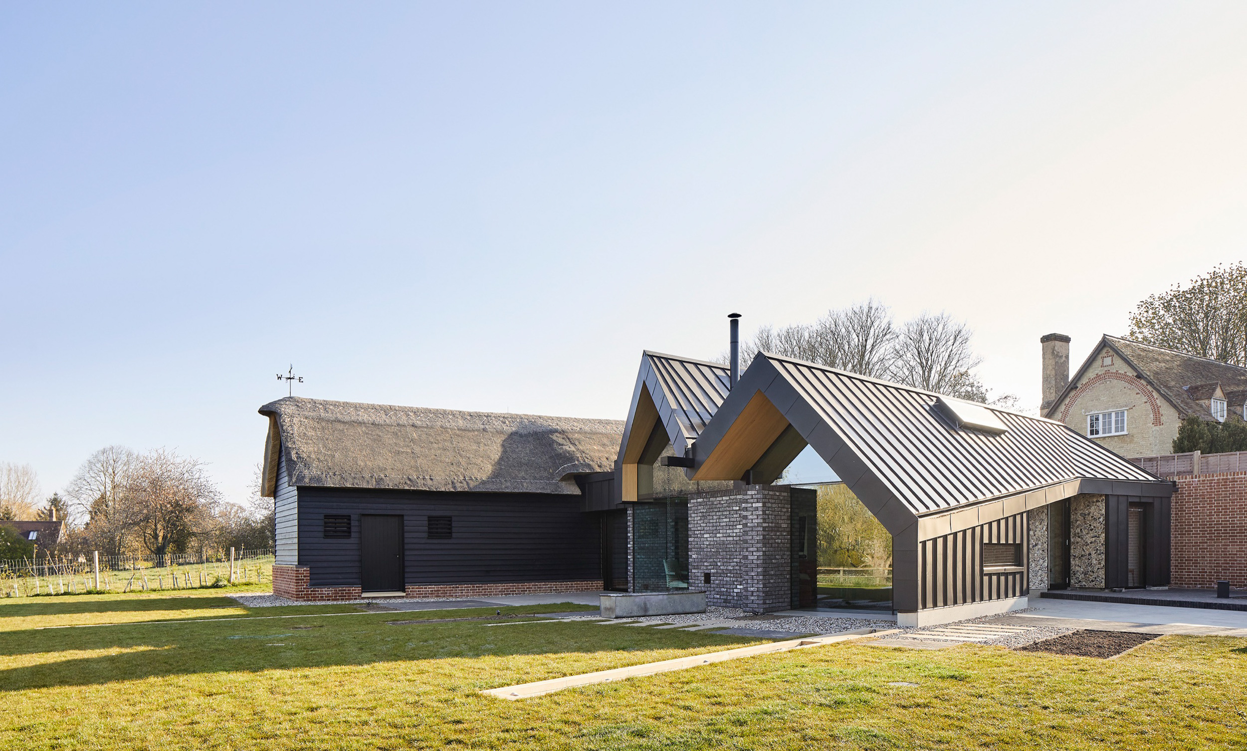 pitched zinc roofs meeting thatched roof at eye-level | cambridge architects CDC Studio