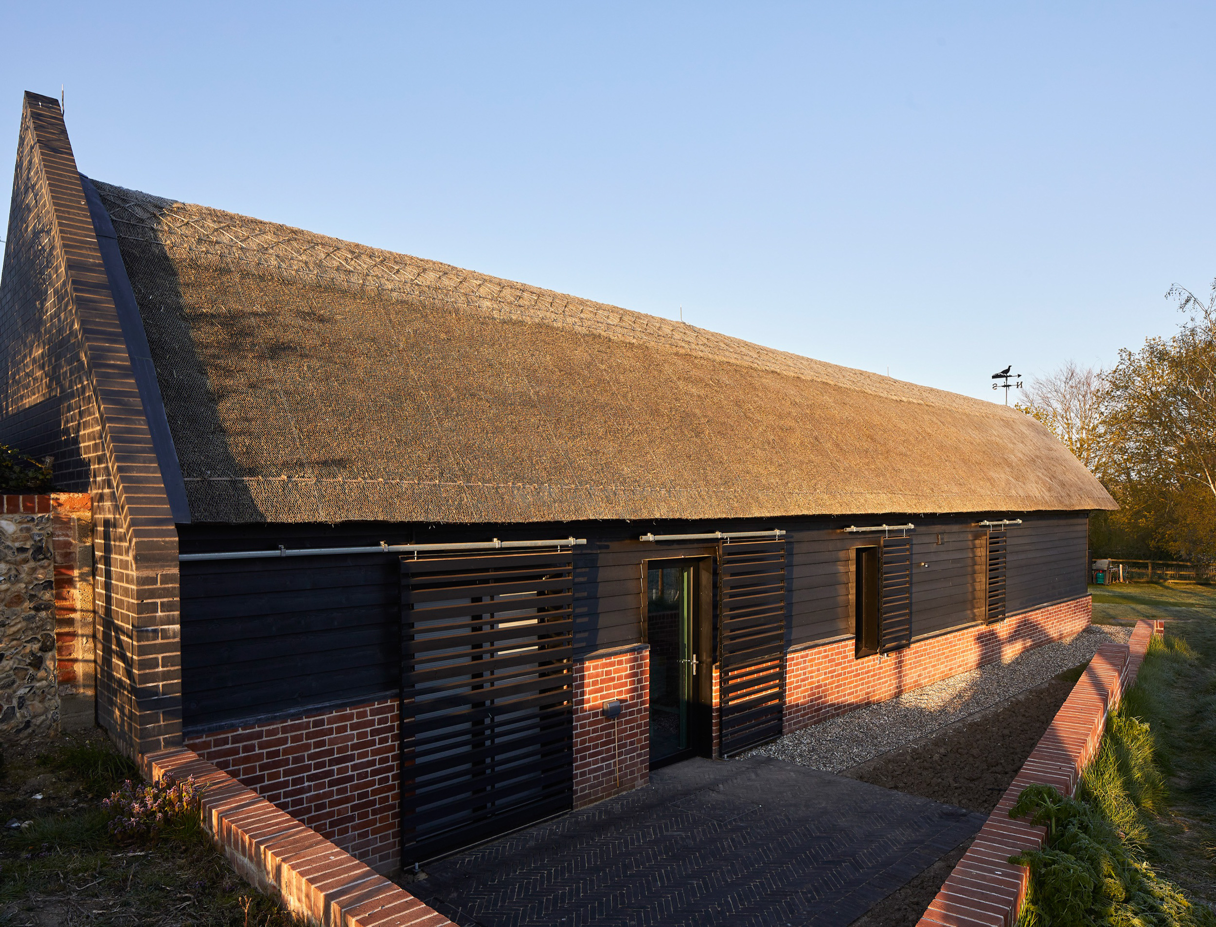 Timber shutters over back door to thatch barn | cdc studio cambridge architects