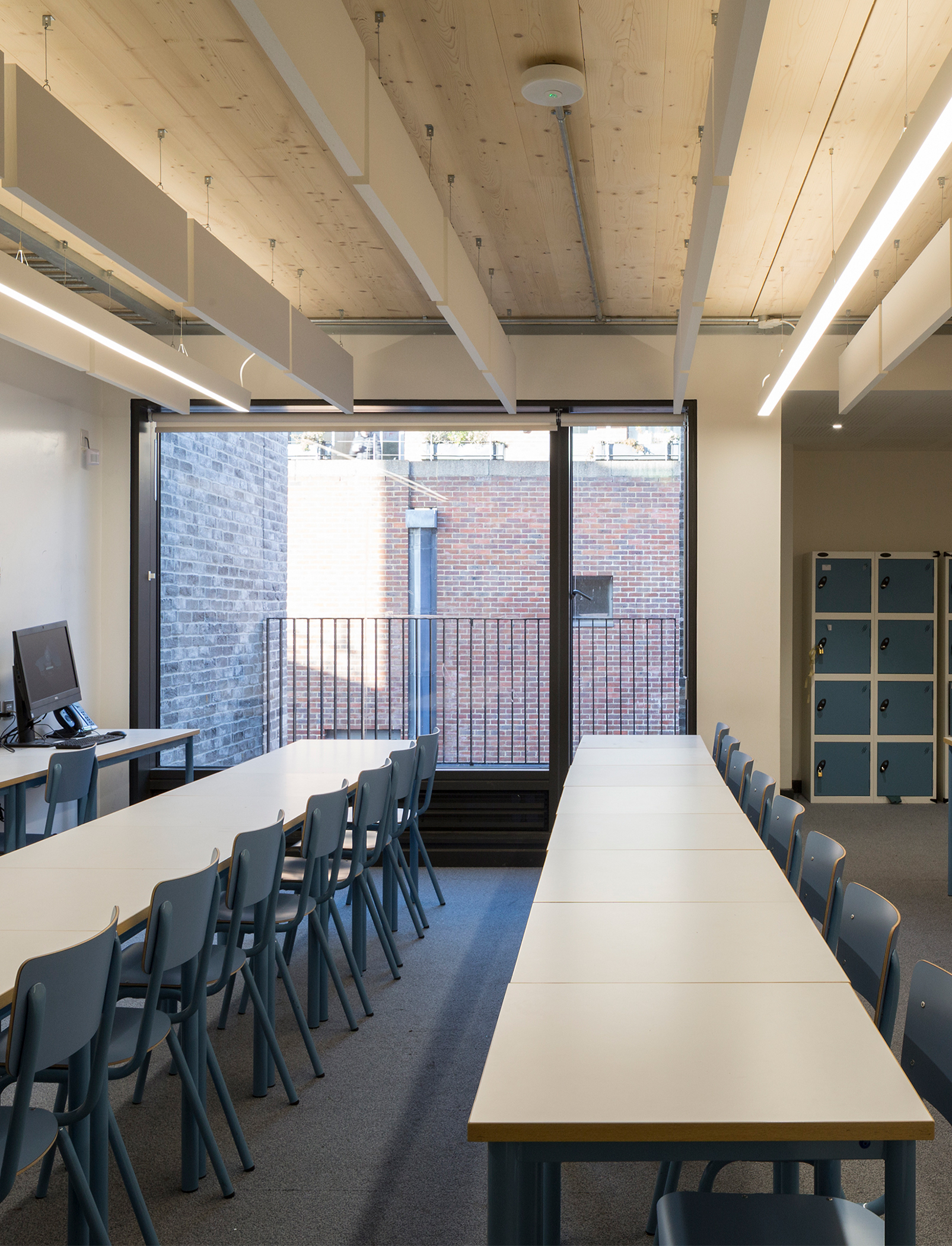 Classroom with window to outside street and overhead lighting, | CDC Studio Cambridge architects