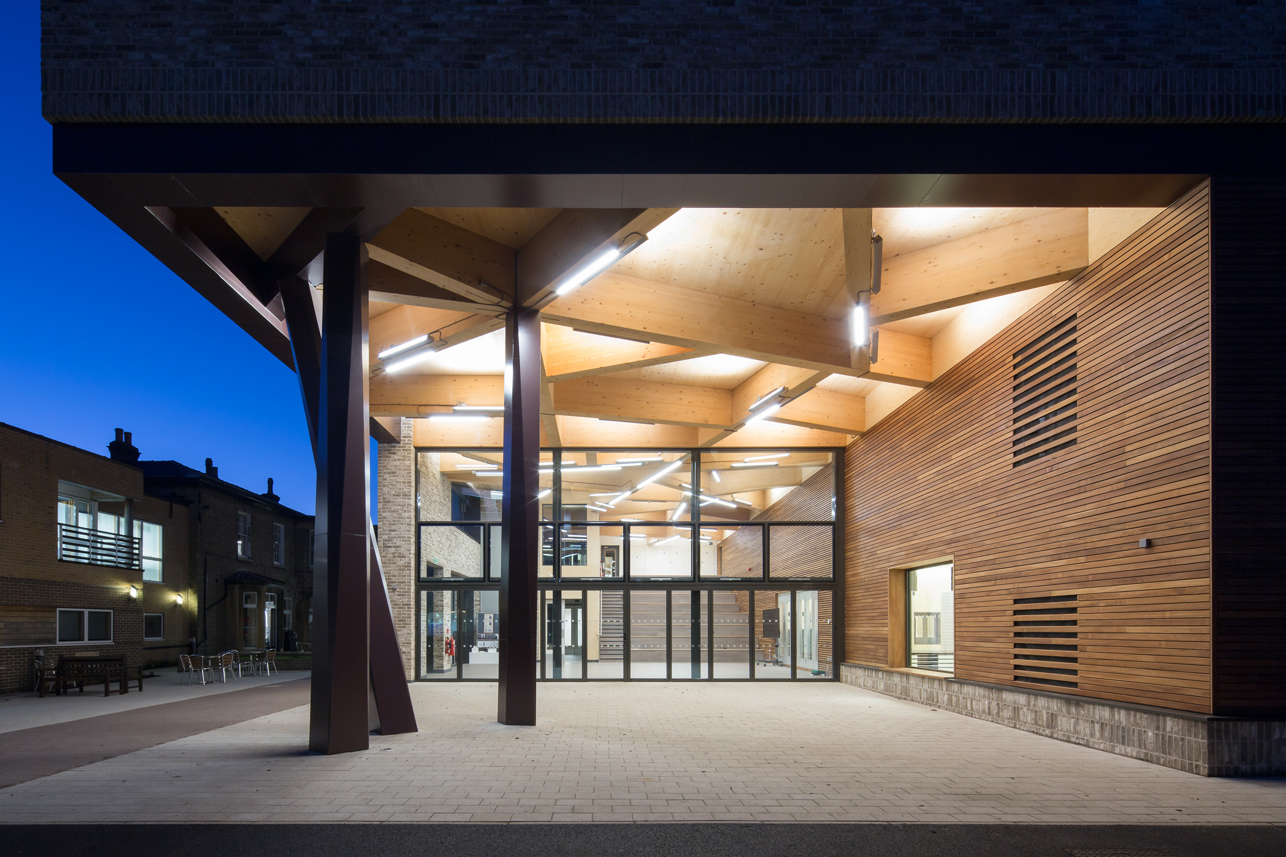 Evening view of entrance overhang with overhead lights in contrast. | CDC Studio Cambridge architects