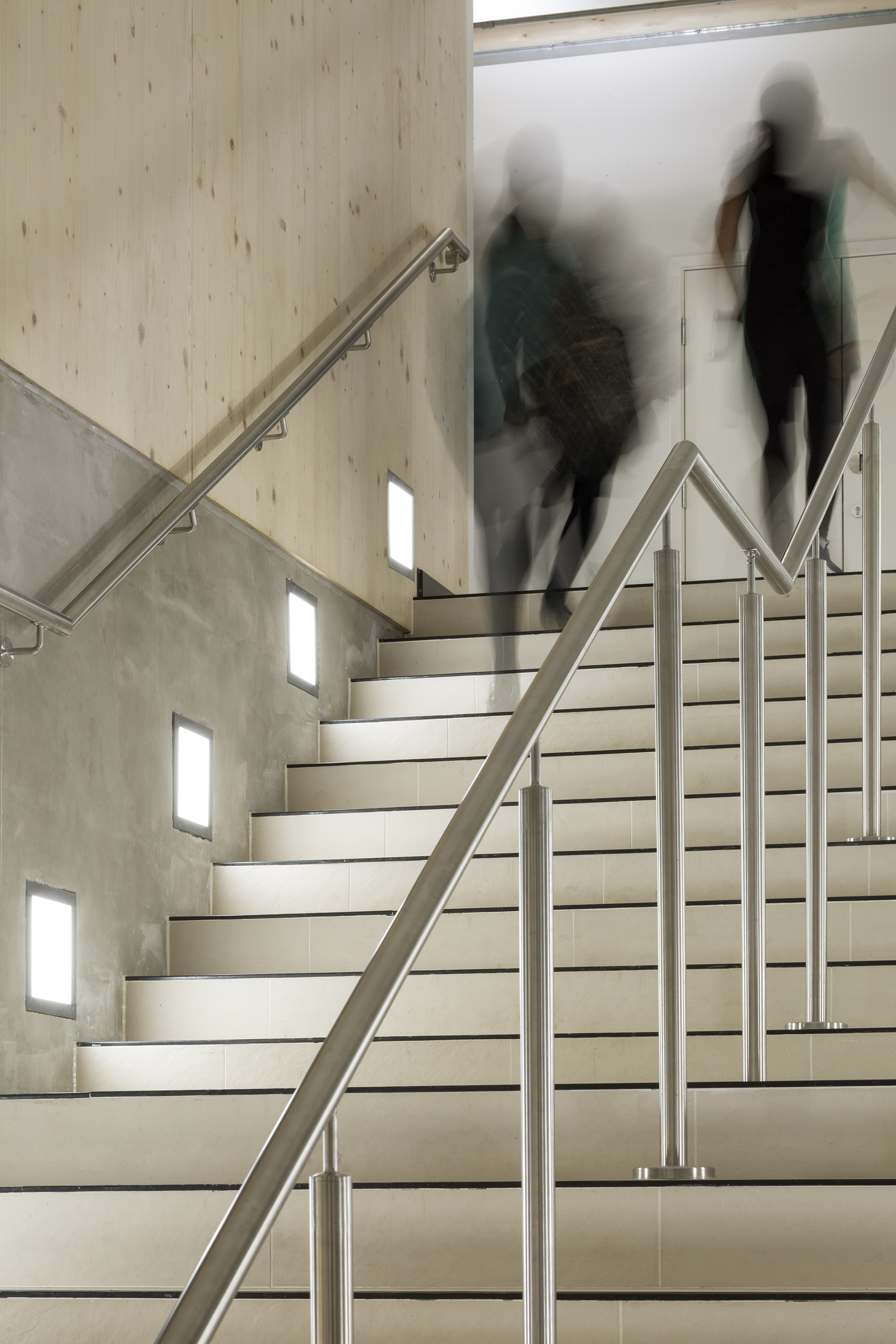 View of stairs from base with sillhouettes of students moving through, | CDC Studio Cambridge architects
