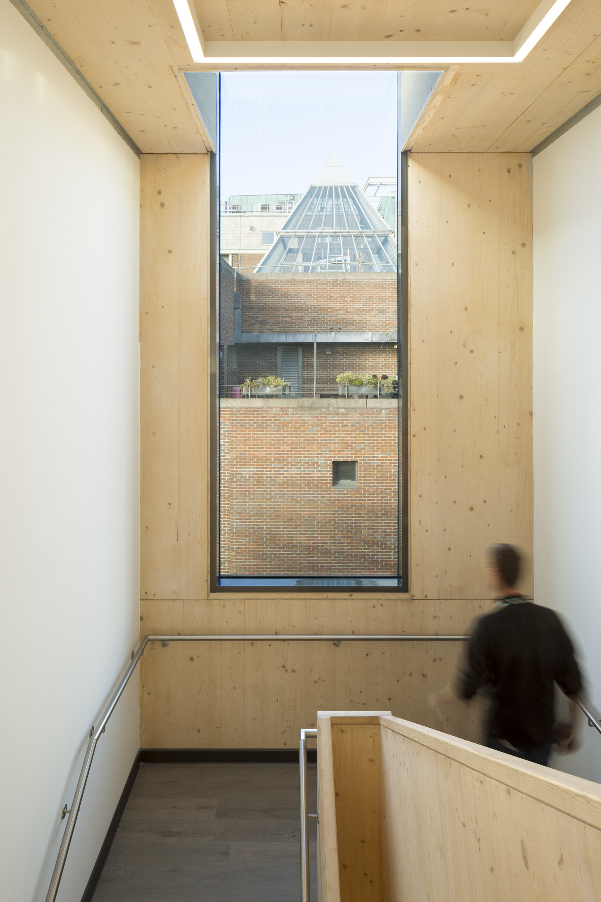 Interior view showing stairs and window with passing sports learning school student. | CDC Studio Cambridge architects